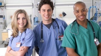 Cast of Scrubs in a hospital smiling at the camera