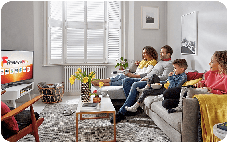 Family sitting on a sofa watching TV