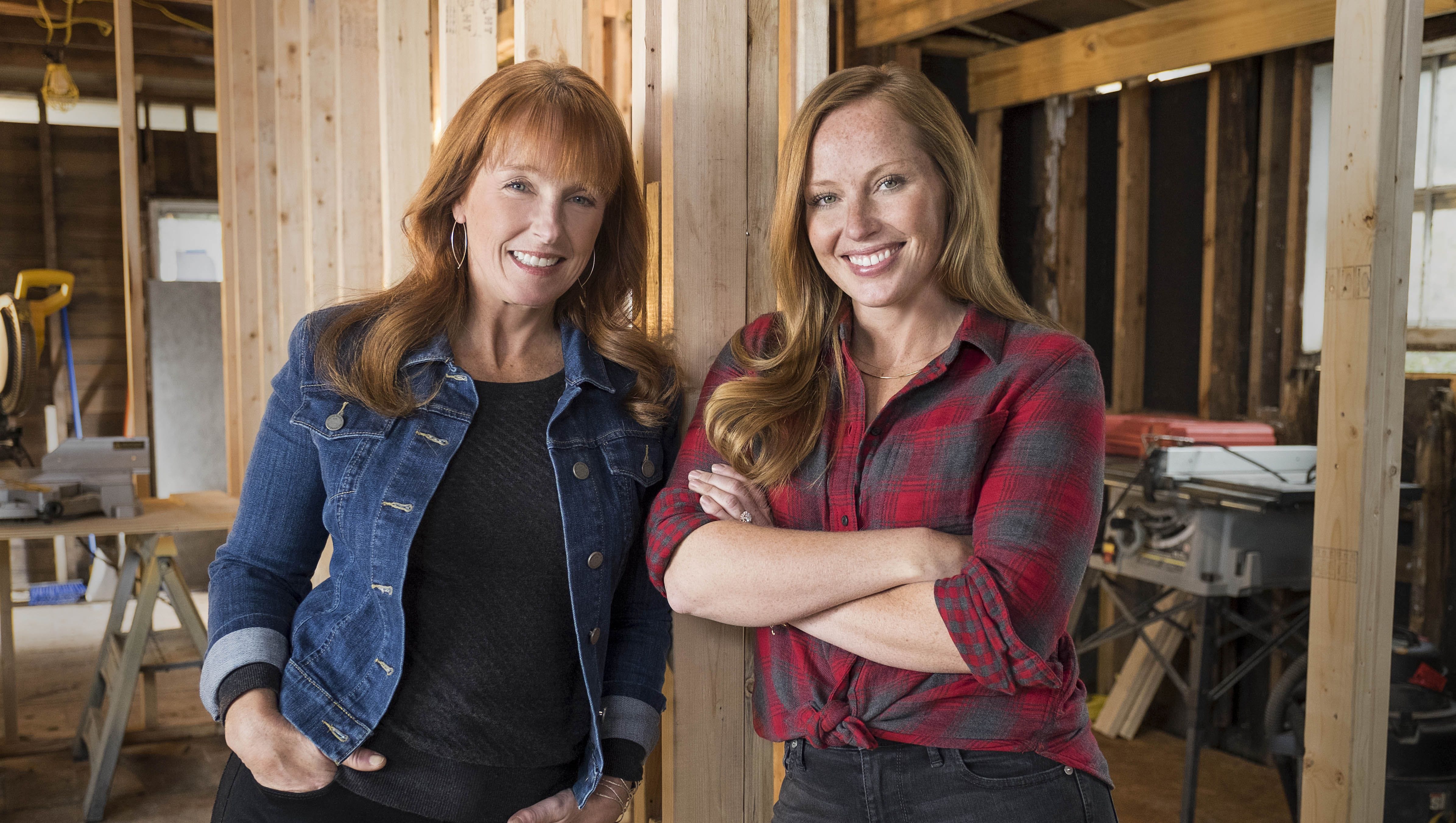 Two women stand smiling on a construction site