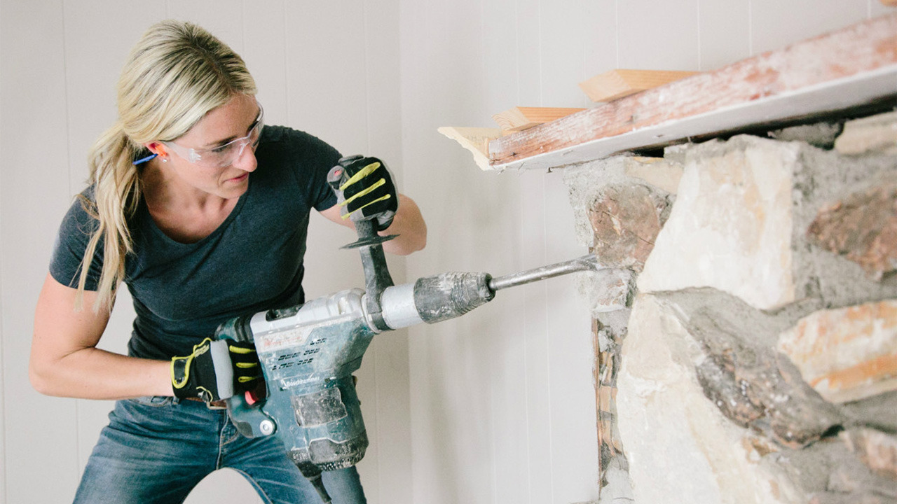 Woman drilling into a wall 