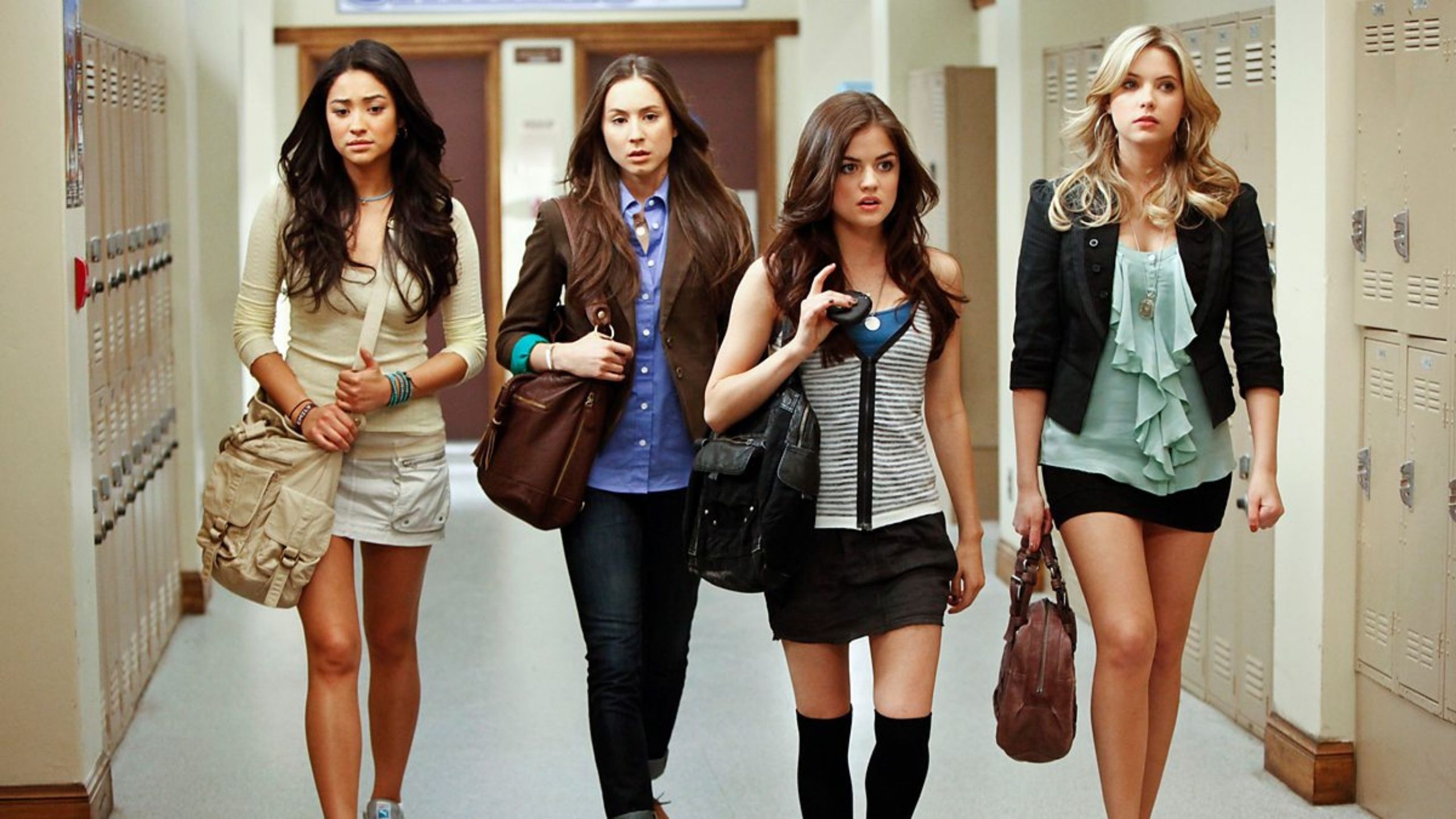 Four young women walking the corridors of a school