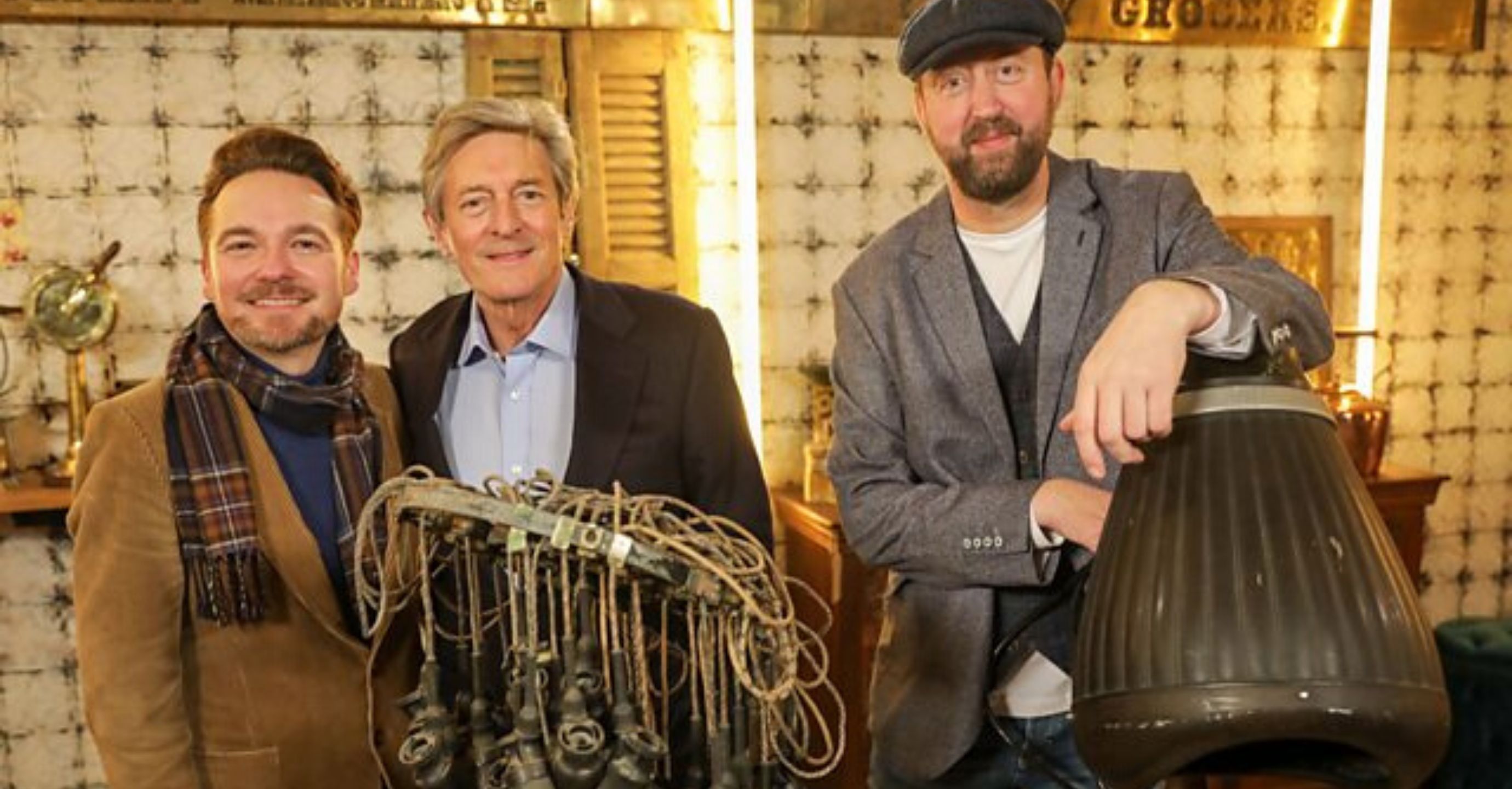 The Bidding Room experts in a softly lit warehouse surrounded by their wares