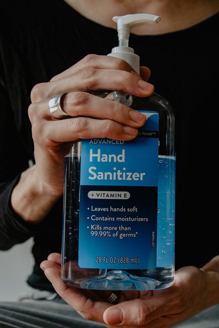 Hands holding a large bottle of hand sanitizer