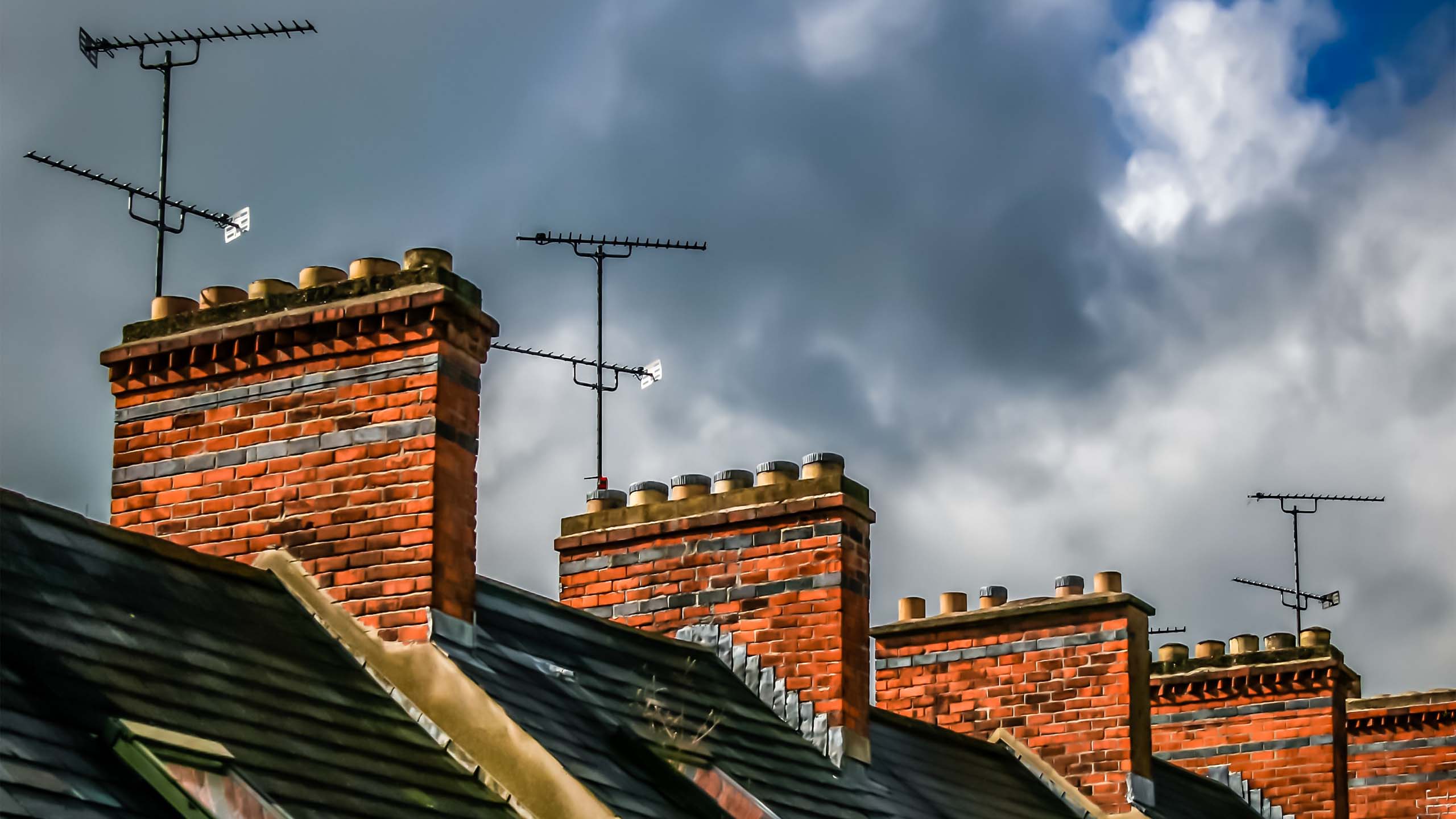 Rooftop view of red brick houses, TV aerials and chimneys (Image credit: Tom O'Neill, Unsplash)