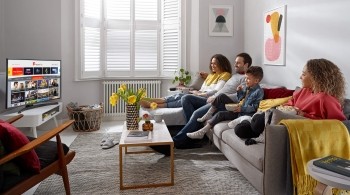 Family sitting on a sofa watching TV