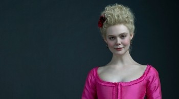 A Caucasian woman in eighteenth century dress against a black background 