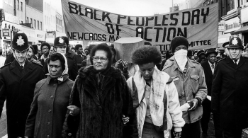 Black and white image of Black protestors from South London in the 60s, surrounded by White policemen