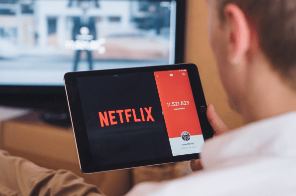 Man watching Netflix on tablet whilst also playing different content on his TV