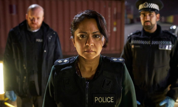 DI Ray flanked by two male police officers