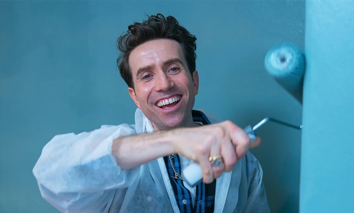 Nick Grimshaw wearing overalls and painting a wall