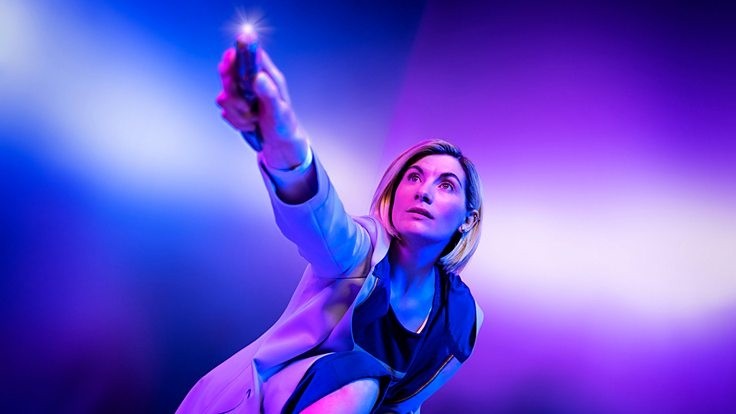 Jodie Whittaker as Doctor Who, crouching down and holding the sonic screwdriver