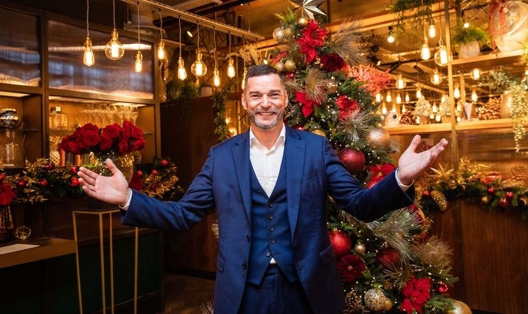 First Dates' Fred Sirieix in front of a Christmas tree