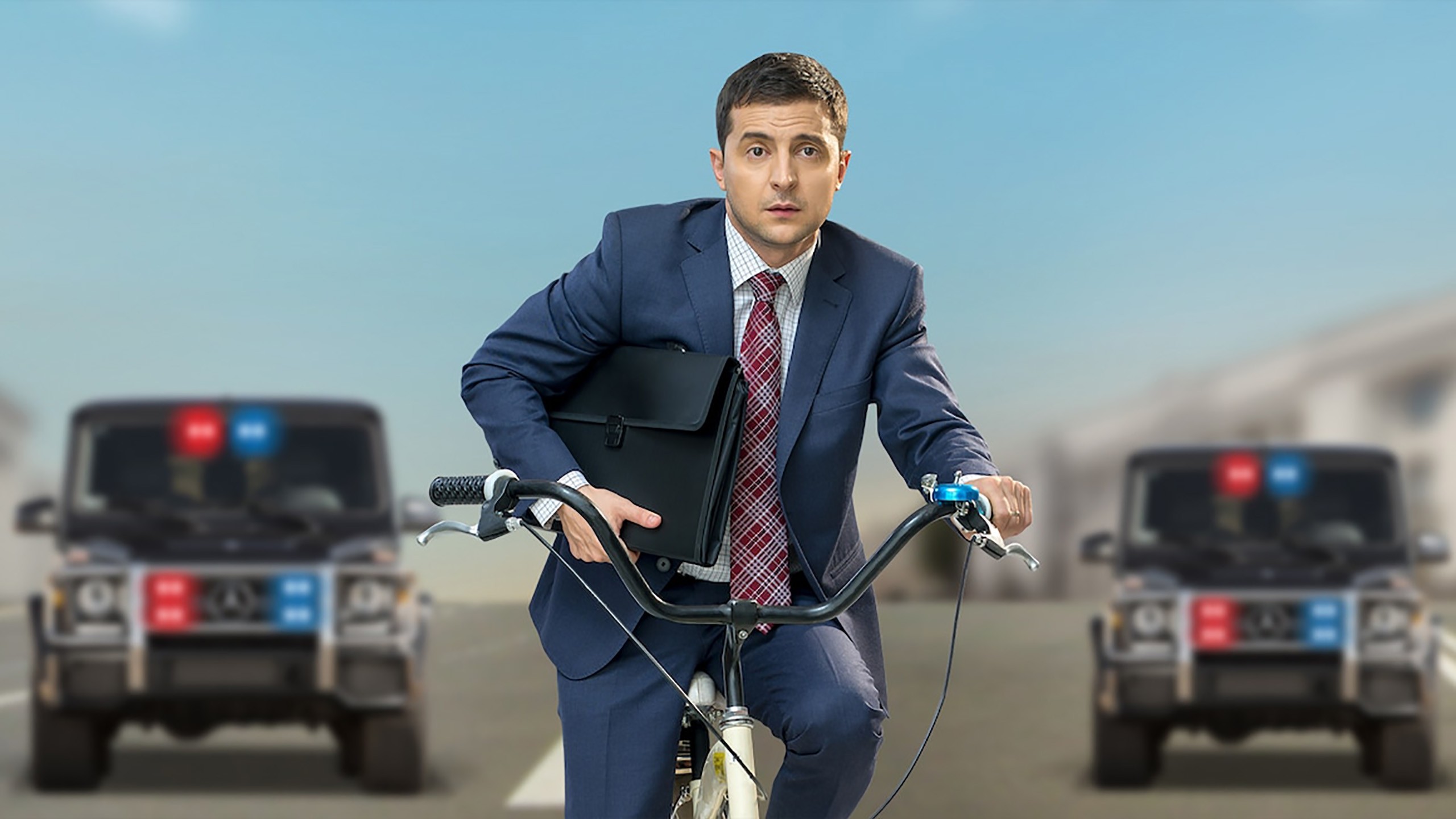 Volodymyr Zelenskyy riding a bike and clutching a briefcase