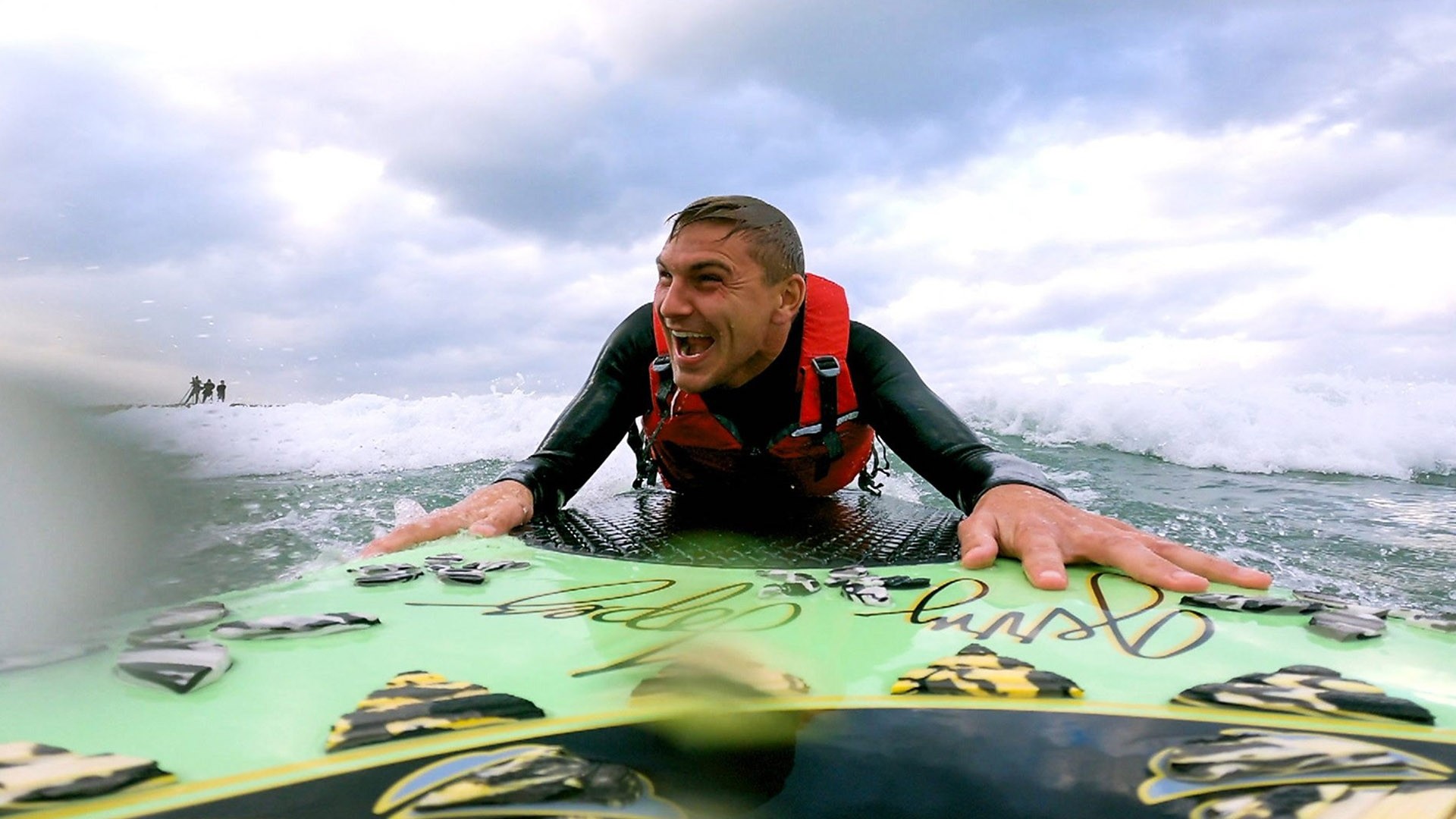 Man in the sea gripping a surfboard