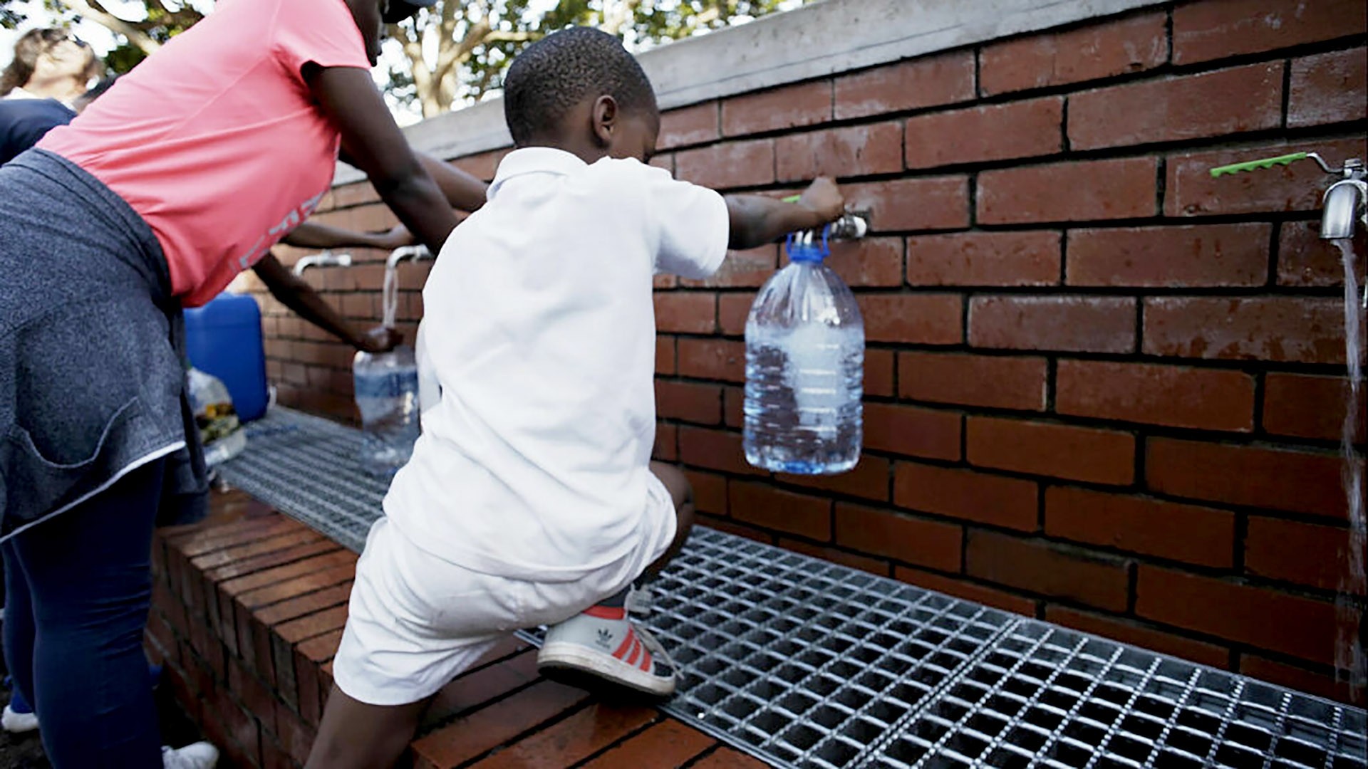 Young boy filling a water bottle