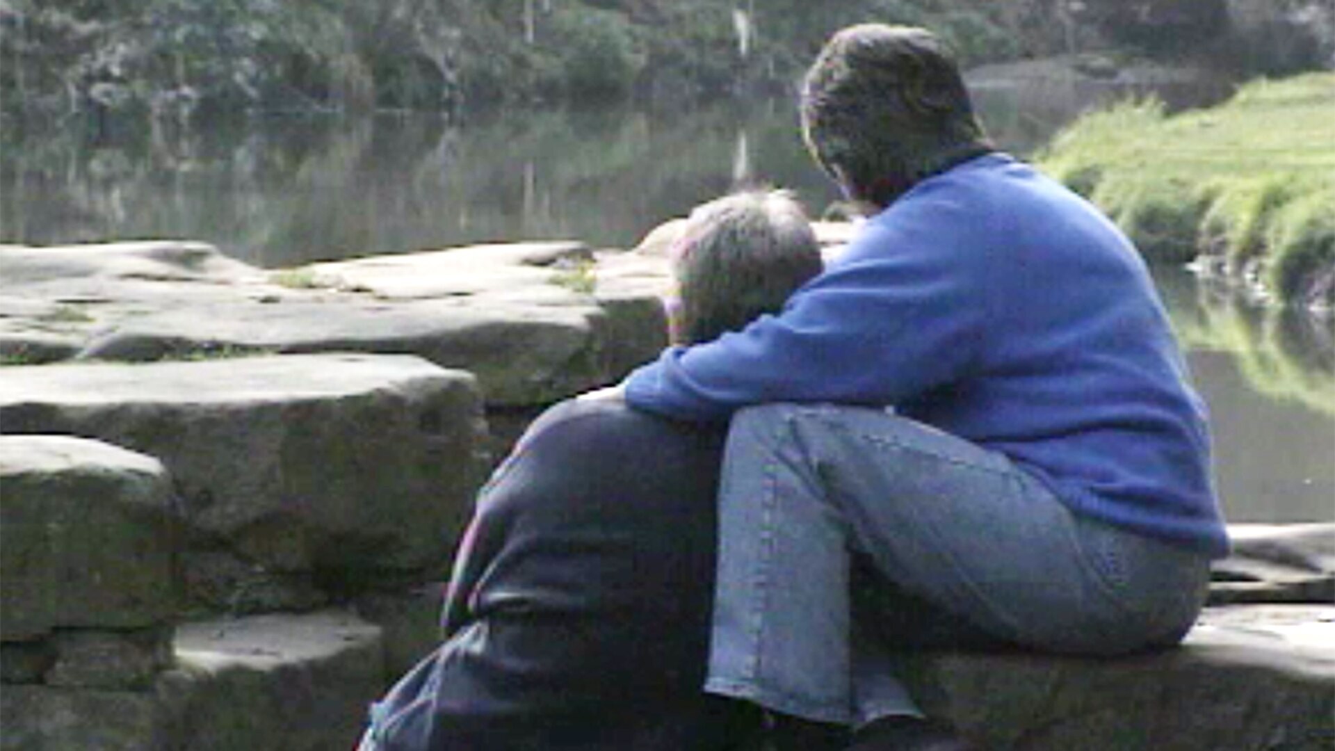 two women embracing by a river