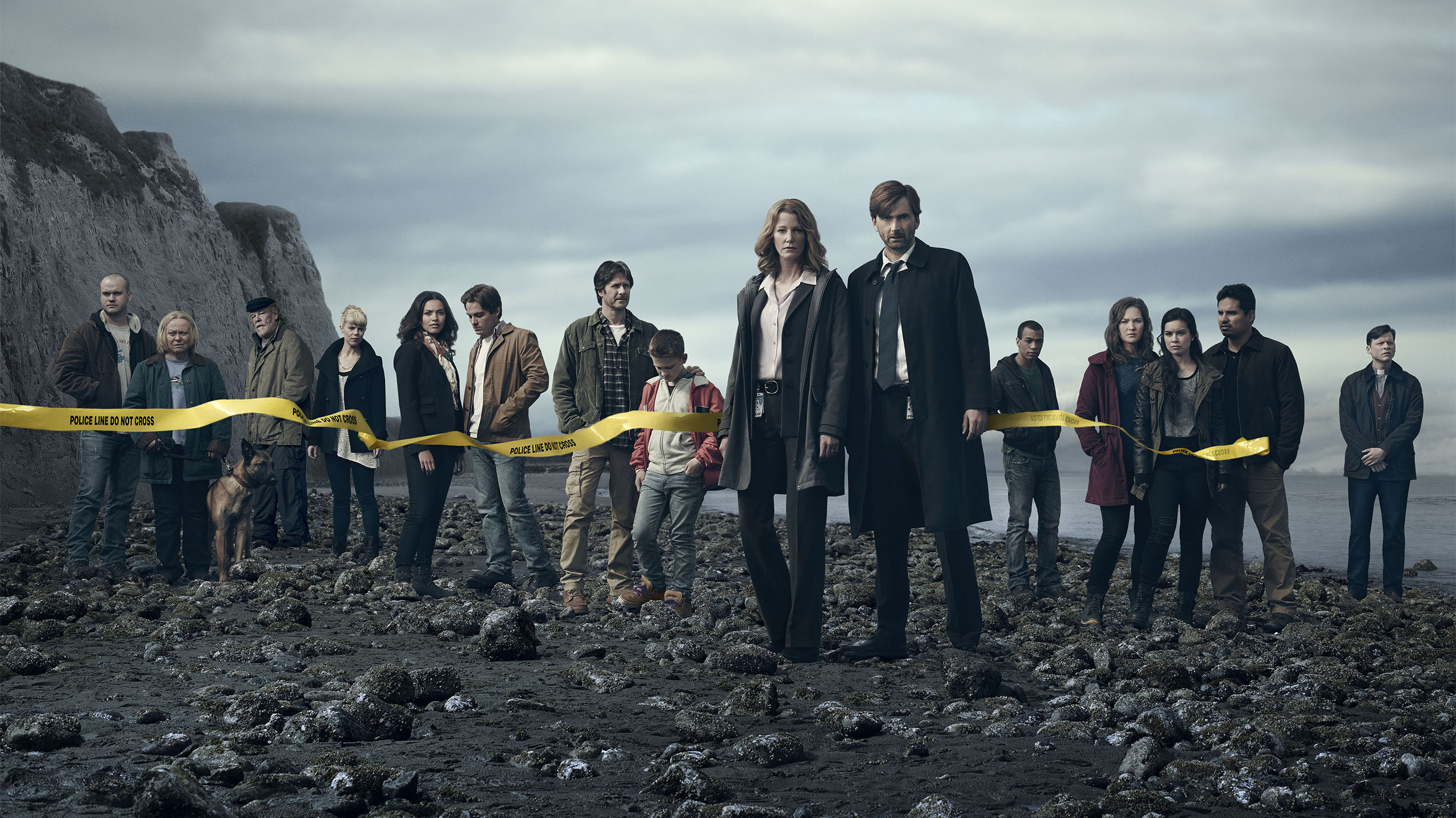 the cast of Gracepoint stood on a beach behind a police line